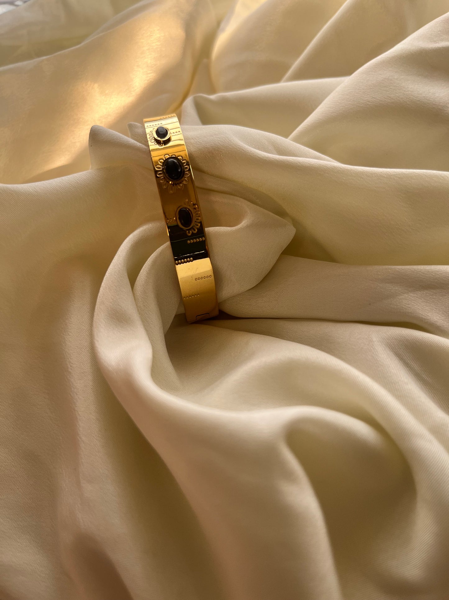 Golden cuff with black stone