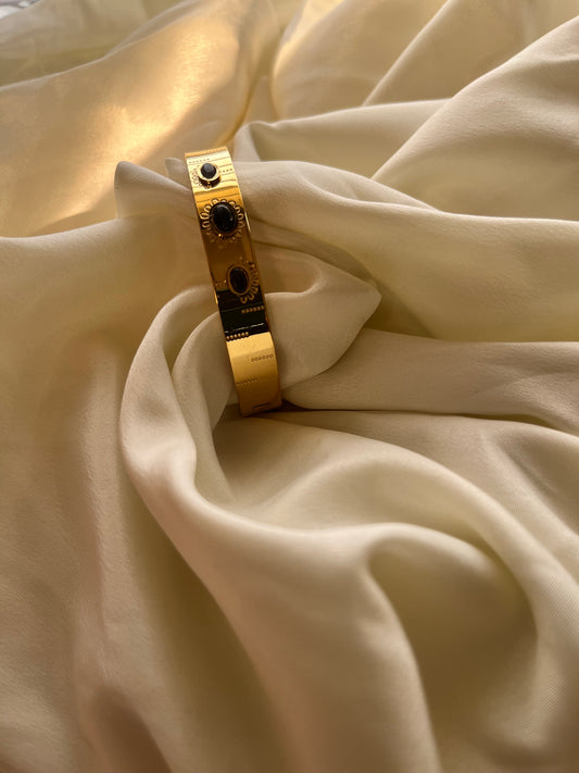Golden cuff with black stone