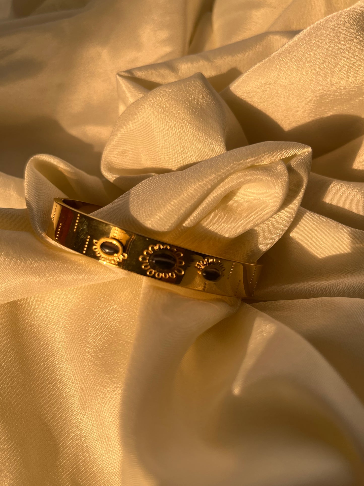 Golden cuff with black stone