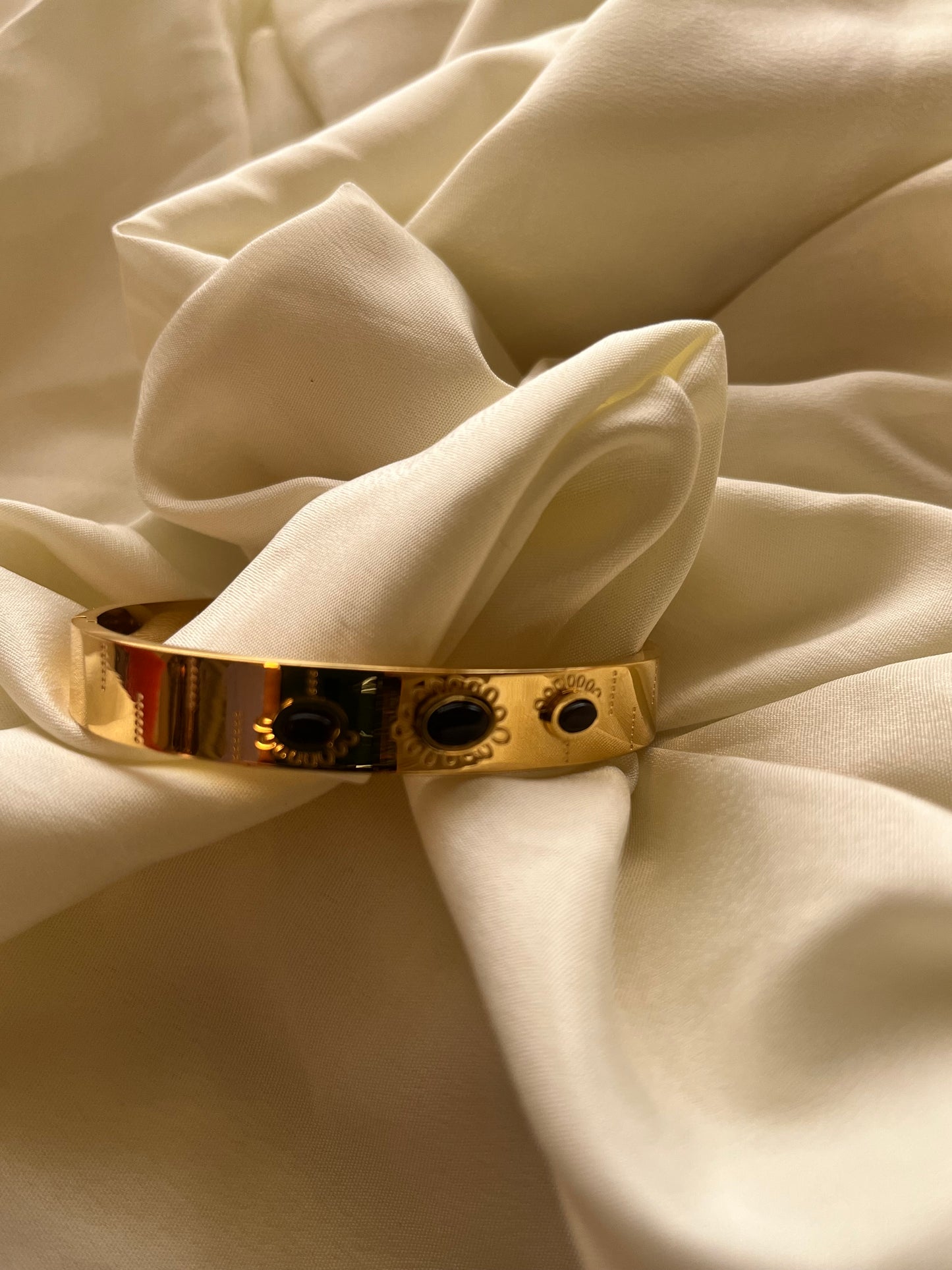 Golden cuff with black stone